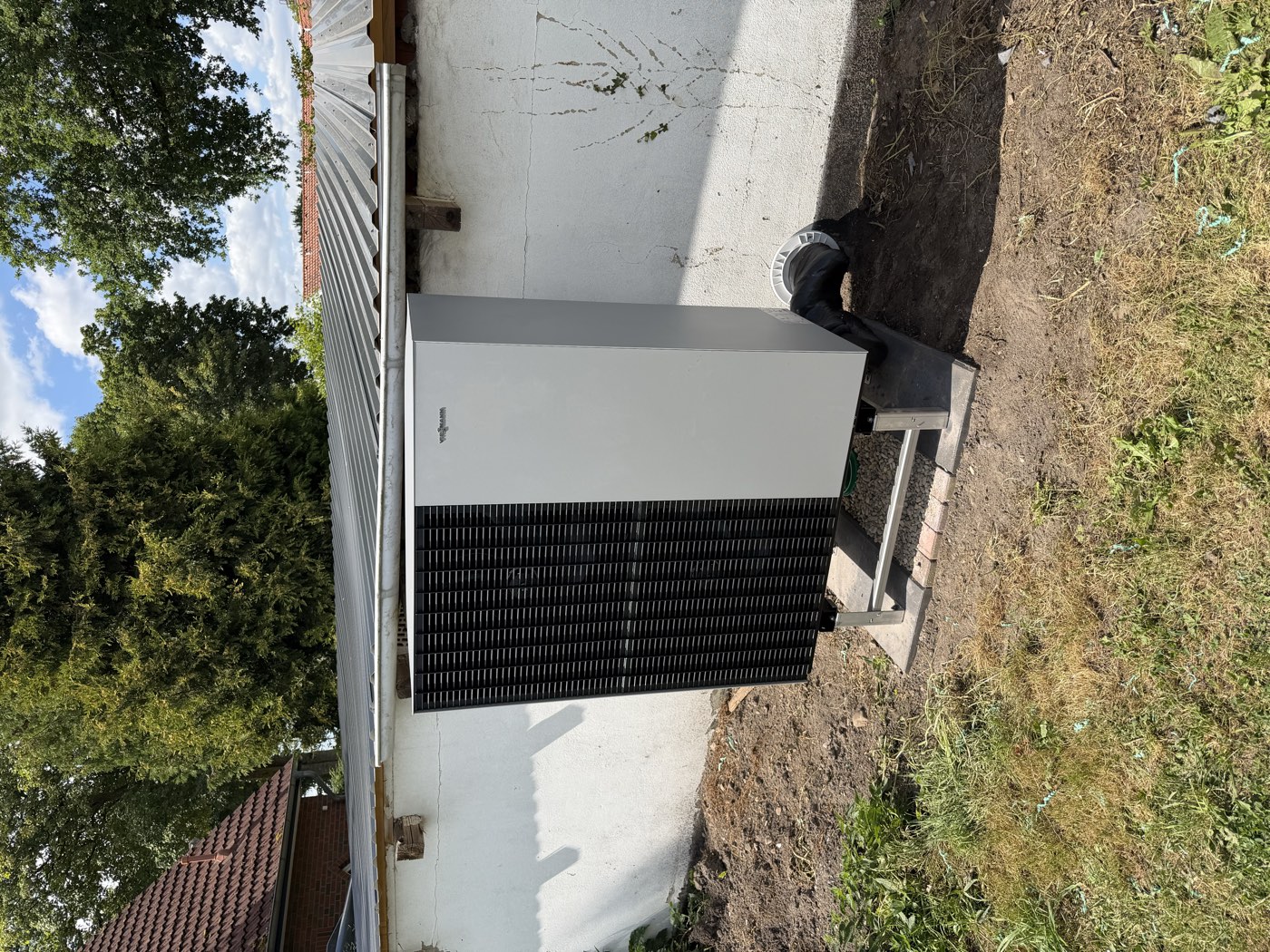 Wärmepumpen-Außeneinheit auf Montageständer im Garten